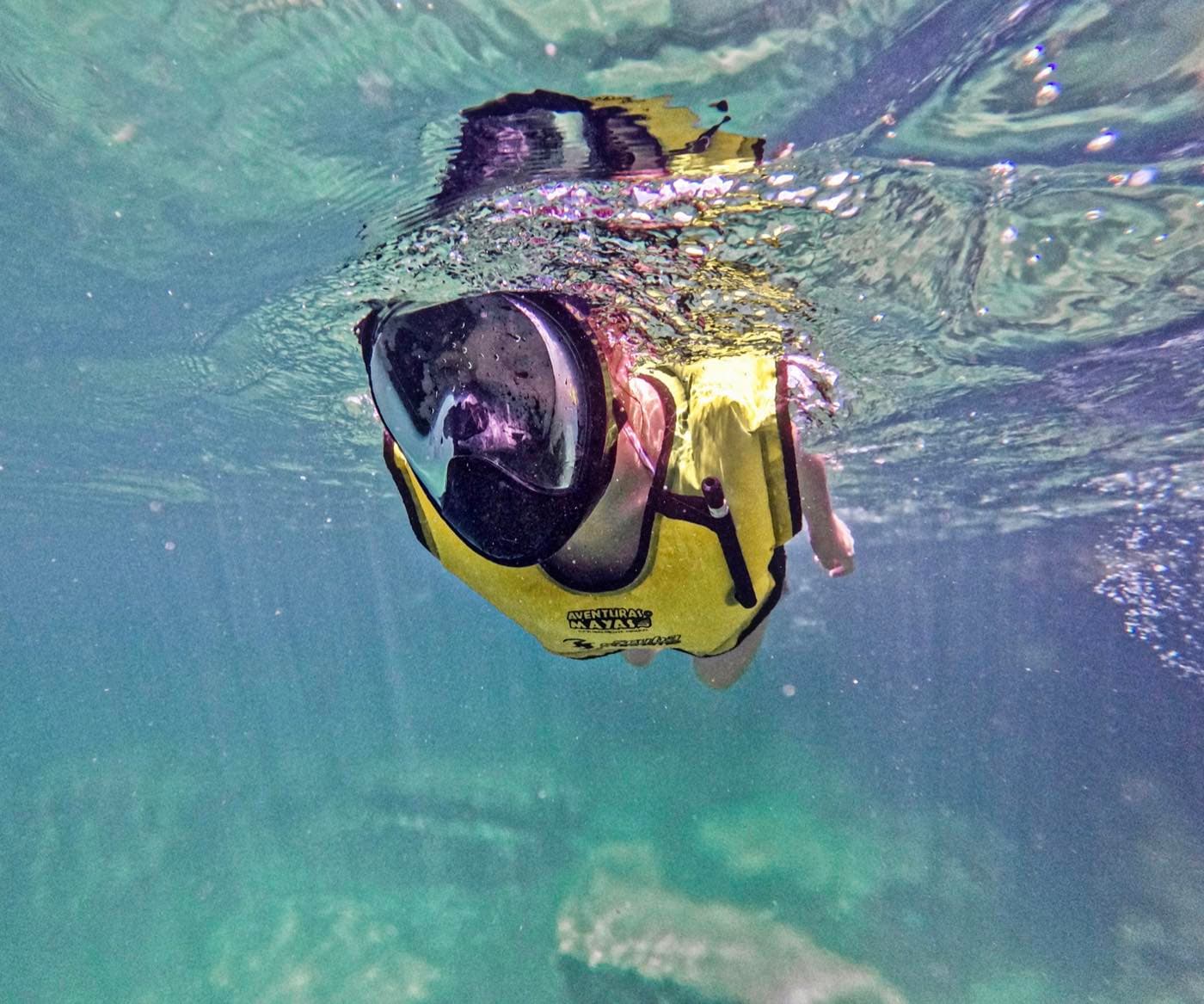 Persona haciendo snorkel con visor integral bajo el agua